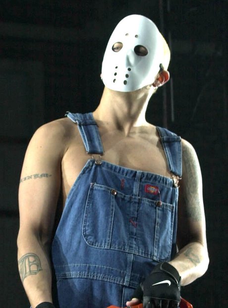 Eminem wearing a white mask and carrying a chain saw