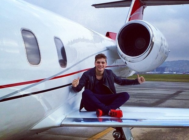 Martin Garrix sitting on a plane wing.
