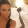 Image 1: Kanye West in bed while Kim Kardashian takes a selfie