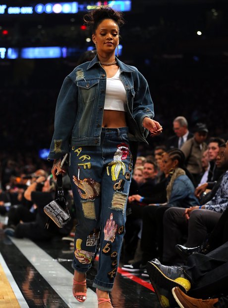 Rihanna at the basketball wearing colourful jeans 