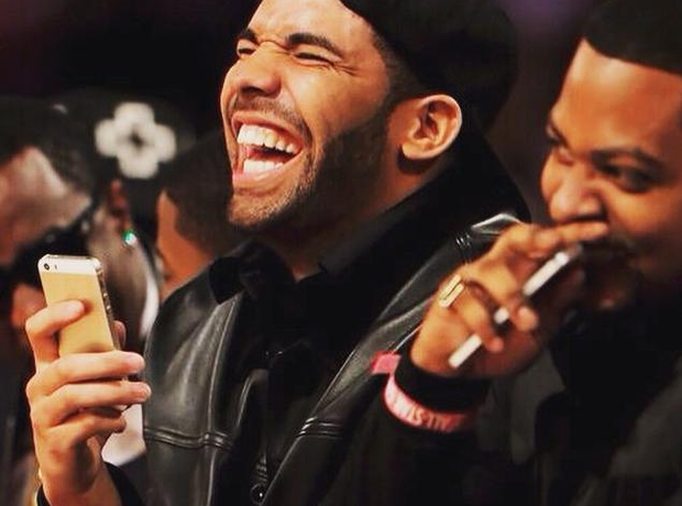 Drake laughing with phone in hand