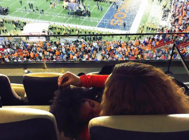 Beyonce and Blue Ivy sitting at american football