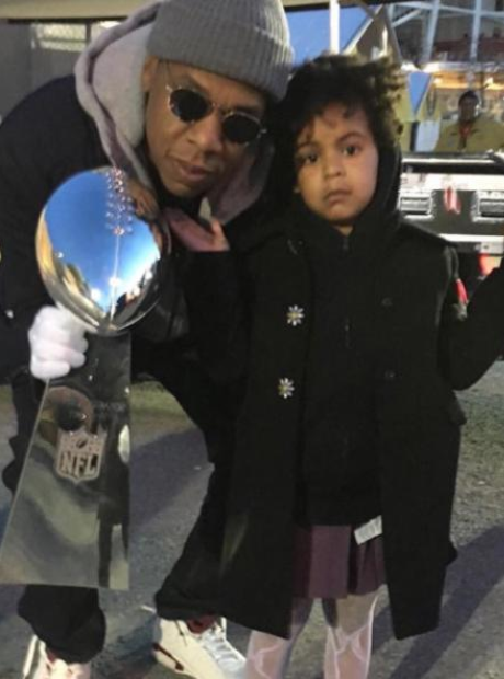 Jay Z holding Superbowl trophy with Blue Ivy