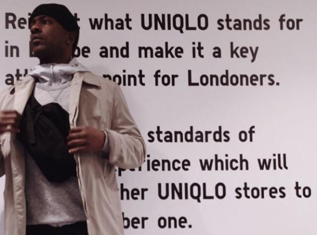 Skepta standing in front of Uniqlo motto