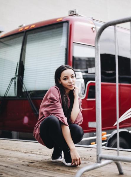 Tinashe standing in front of tour bus