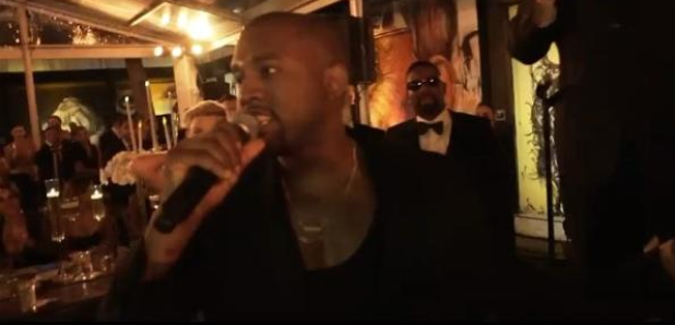 Kanye West holding microphone