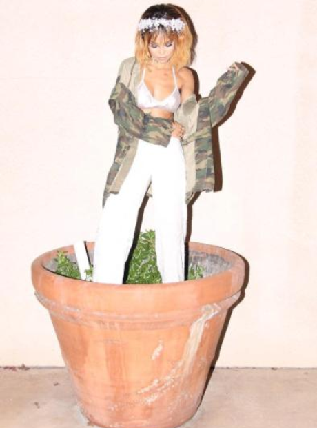 Jhene Aiko standing in plant pot